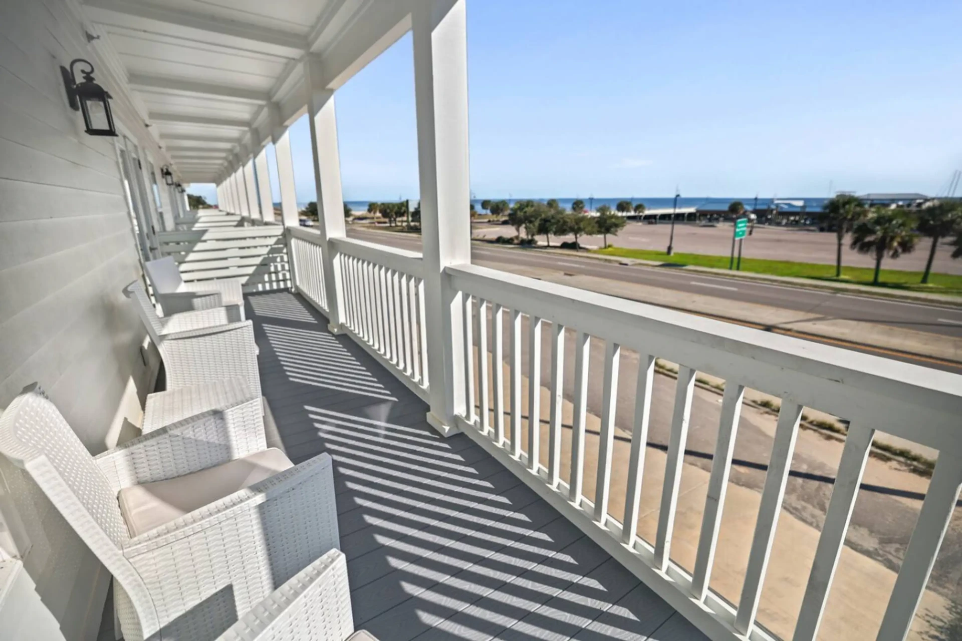 Porch with white wicker chairs overlooking the Gulf