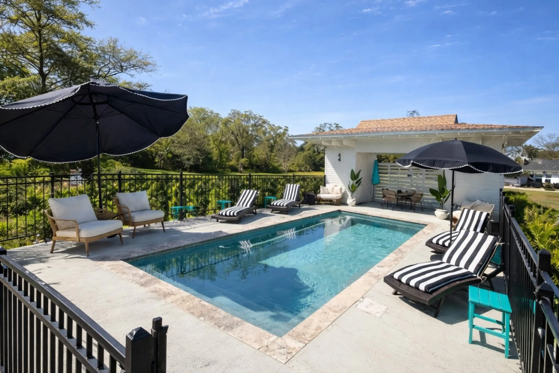 Private pool with striped loungers and umbrellas