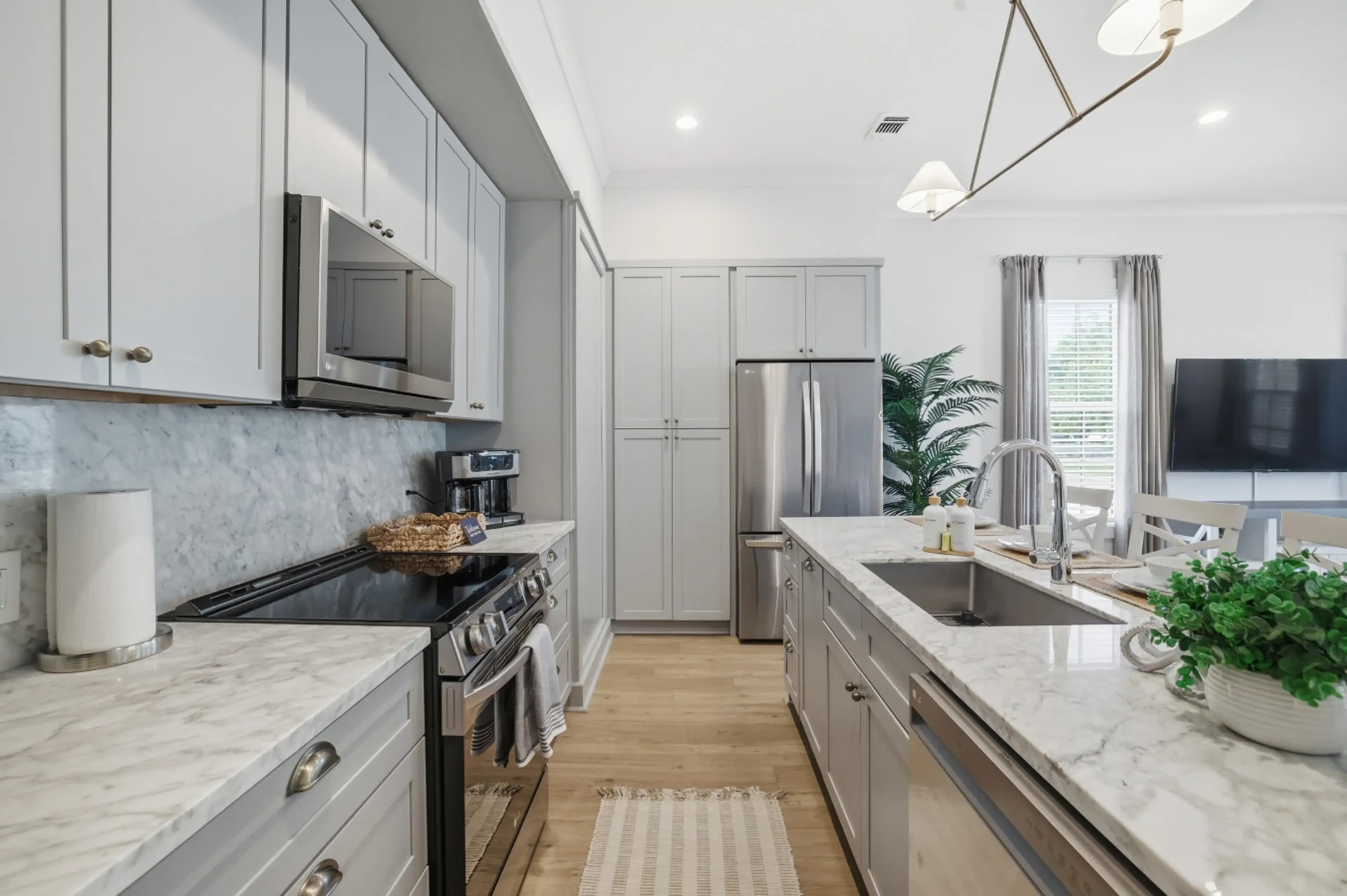 Bright modern kitchen with marble counters and stainless appliances